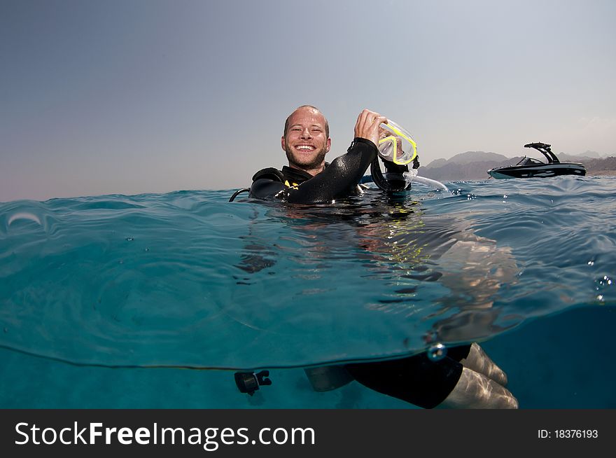 Scuba diver cleans his mask on the surface before dive. Scuba diver cleans his mask on the surface before dive