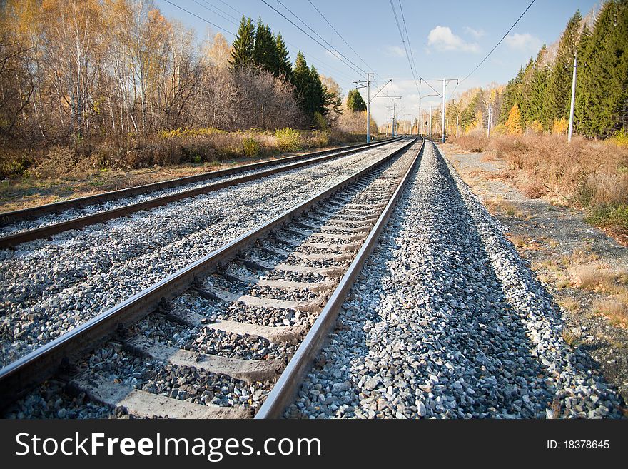 Railway tracks stretching into the distance, autumn landscape on both sides. Railway tracks stretching into the distance, autumn landscape on both sides