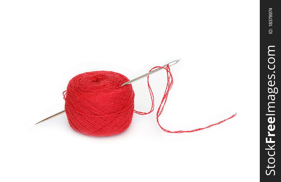 Clew Of Red Thread With Needle On White Background