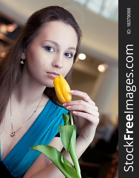 Girl with yellow tulip in cafe