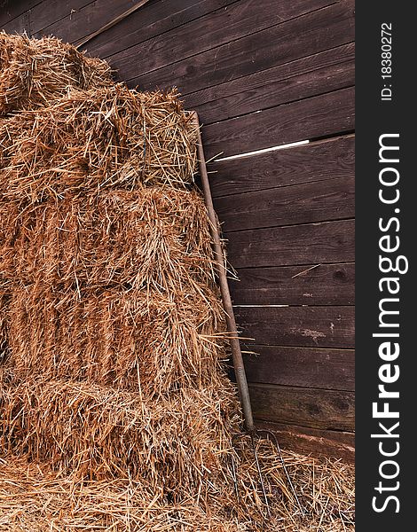 Idyllic scene with a pitchfork and straw in front of a cowshed