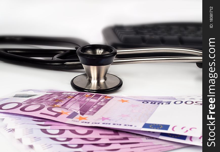 Stack of 500 euro banknotes with a stethoscope and a keyboard in the background. Stack of 500 euro banknotes with a stethoscope and a keyboard in the background