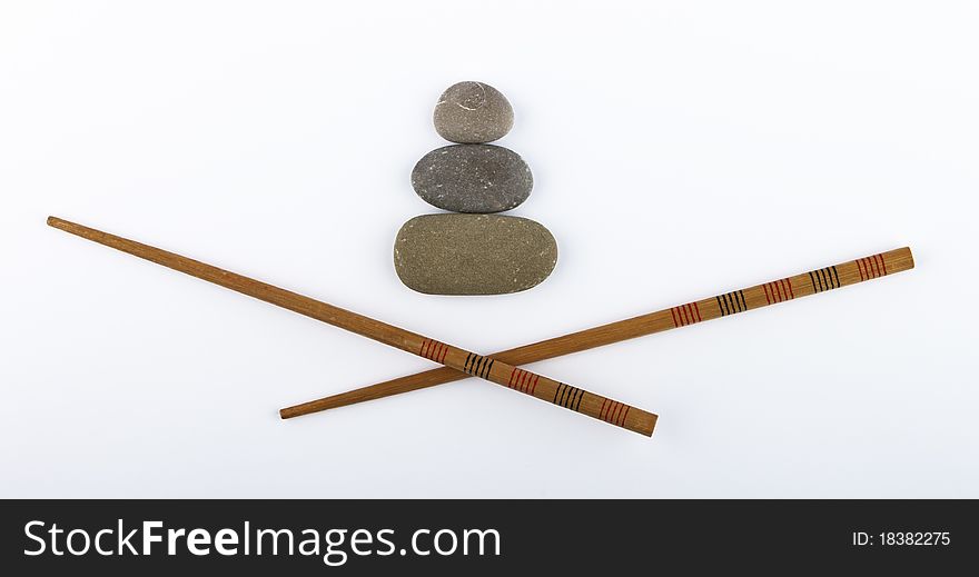 Chopsticks and stones isolated on white background