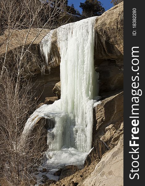 View of a waterfall frozen solid during the winter season. View of a waterfall frozen solid during the winter season.