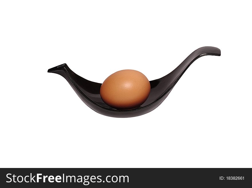 Beige egg on a black plastic plate in form of bird