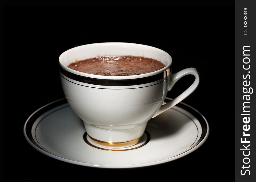 A white cup of how chocolate drink, on black background. A white cup of how chocolate drink, on black background