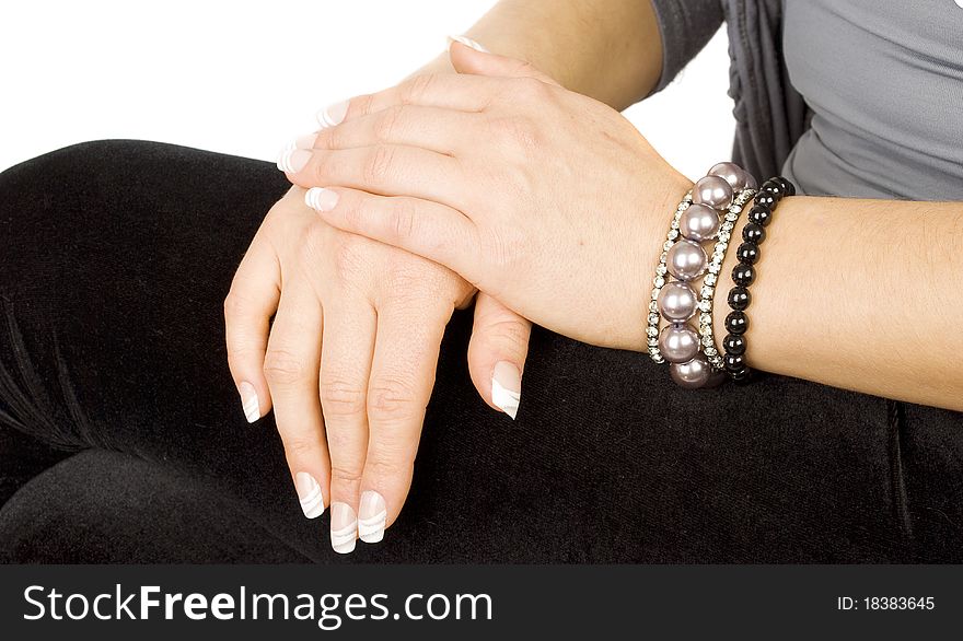 Hands and professional art manicure with pearls beans braslets  on the woman arms.