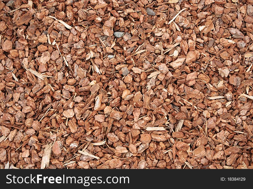 Closeup of red wood chip mulch used to control weeds on flower and vegetable beds. Closeup of red wood chip mulch used to control weeds on flower and vegetable beds