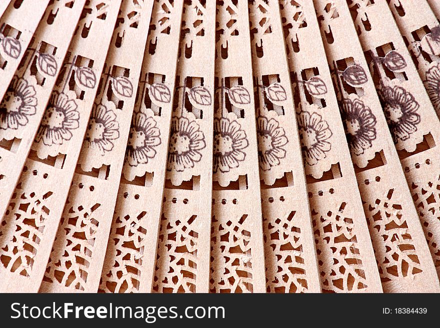 Macro shot of a fan with floral pattern; background