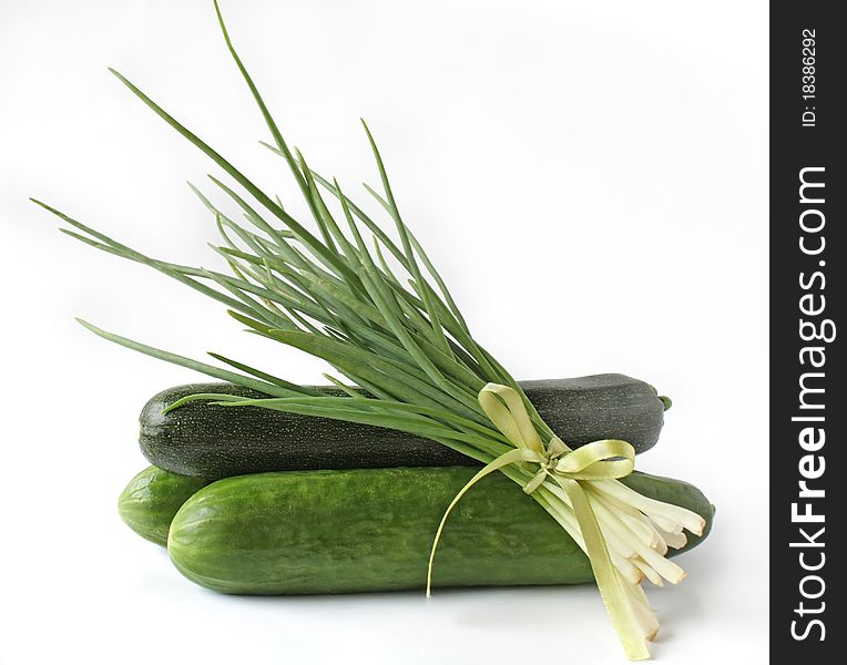 Bunch green onions cucumbers and zucchini on a white background