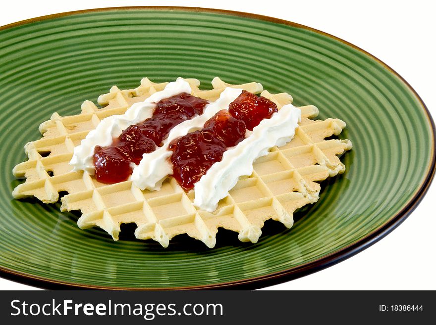 Sweet waffle with cream and jam on green plate