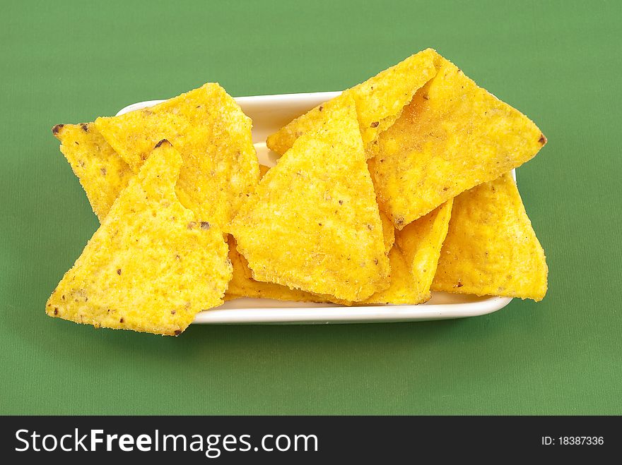 Mexican chips in the foreground on a green background. Mexican chips in the foreground on a green background