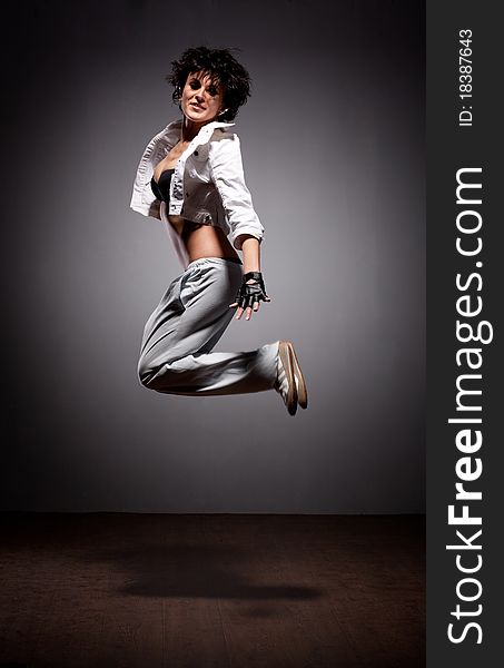 Portrait of jumping dancing woman in street style