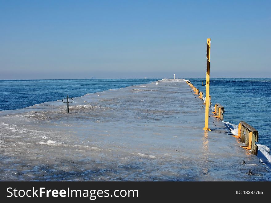 Ice covered pier on lake ontario in winter