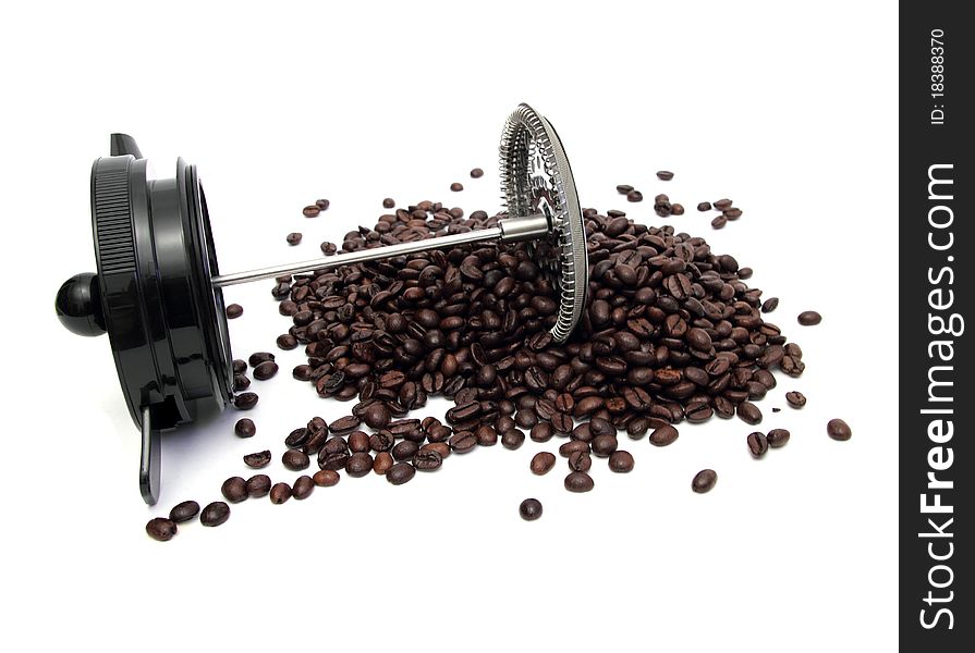 A piece of bod-um coffee machine lying on a pile of coffee beans. A piece of bod-um coffee machine lying on a pile of coffee beans
