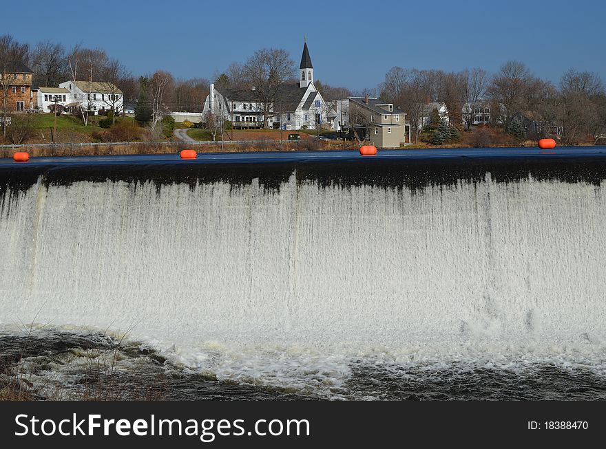 The Dam in Pittsfield NH, The lake is behind the Orange barrier with a view of some shore line behind the Dam. The Dam in Pittsfield NH, The lake is behind the Orange barrier with a view of some shore line behind the Dam.