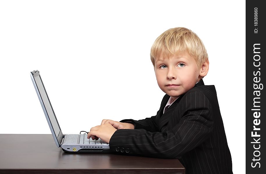 Boy in a suit sitting with a laptop. Boy in a suit sitting with a laptop