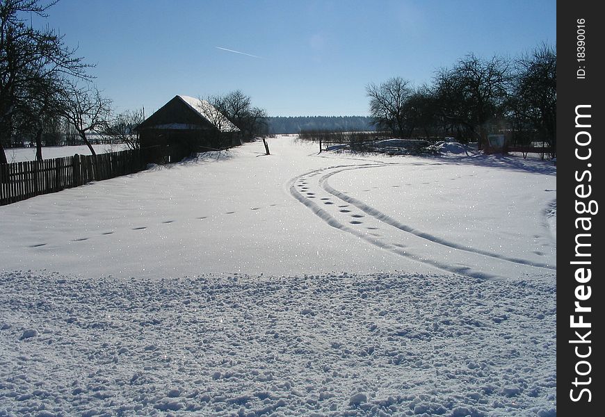 Village in the winter. The rural house, trees , shades, Traces on snow