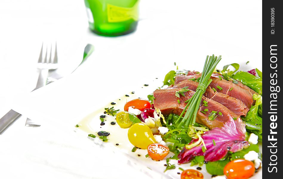 A prime cut of grilled, tender fillet beef on a healthy, and colourful herb salad. A prime cut of grilled, tender fillet beef on a healthy, and colourful herb salad.