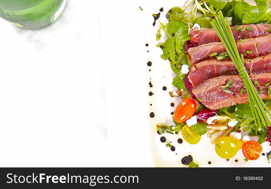 A prime cut of grilled, tender fillet beef on a healthy, and colourful herb salad. A prime cut of grilled, tender fillet beef on a healthy, and colourful herb salad.
