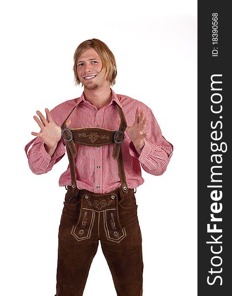 Bavarian man with oktoberfest leather trousers (lederhose) holds suspenders. Isolated on white background.