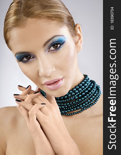 Beautiful young female face with bright fashion multicolored make-up and beauty black manicure of fingernails. Beautiful young female face with bright fashion multicolored make-up and beauty black manicure of fingernails