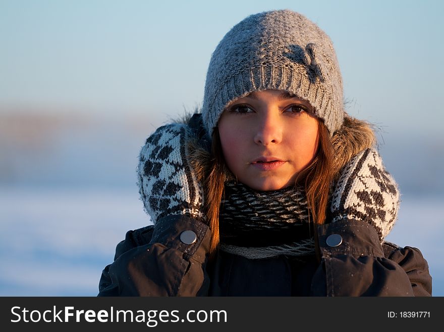 Portrait of a beautiful young girl in the sunlight in the cold