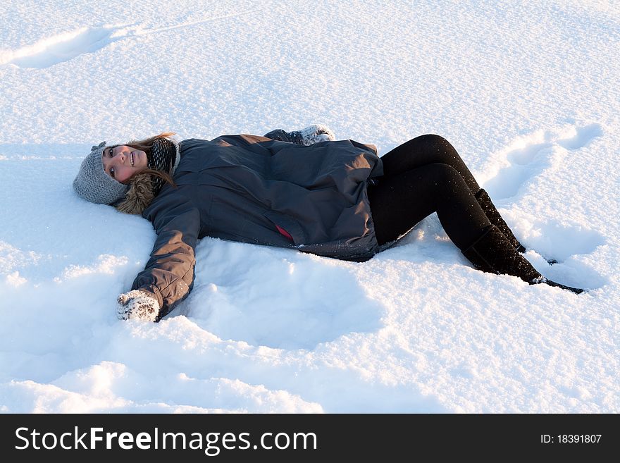 Beautiful young girl rests in the snow