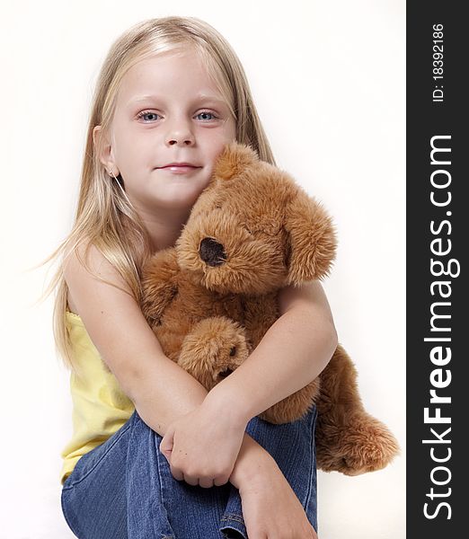 Little girl with teddy bear looking at camera with shy smile. Little girl with teddy bear looking at camera with shy smile