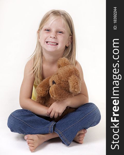 Little girl with a teddy bear smiling funny. Little girl with a teddy bear smiling funny