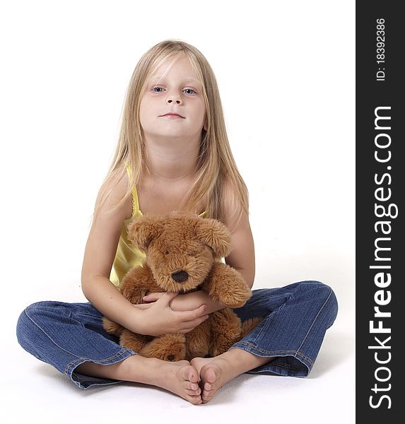 Girl with shy expression with her teddy bear in a tigh hug. Girl with shy expression with her teddy bear in a tigh hug.