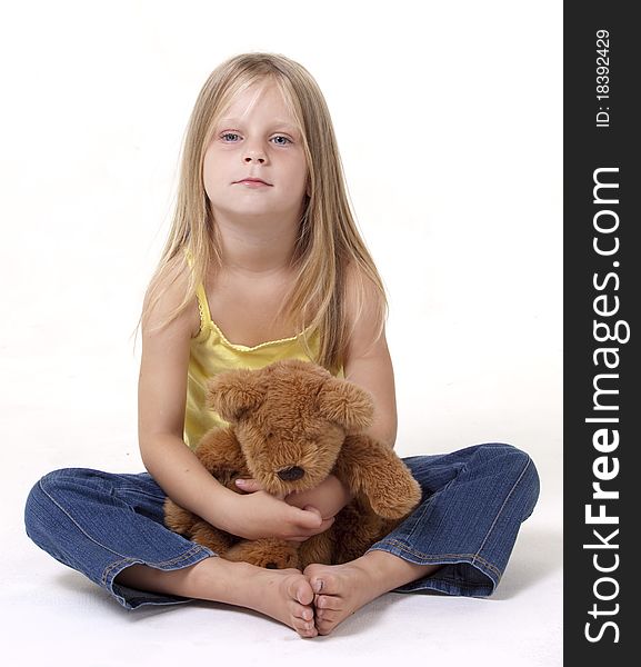 Girl with shy expression with her teddy bear in a tigh hug. Girl with shy expression with her teddy bear in a tigh hug.