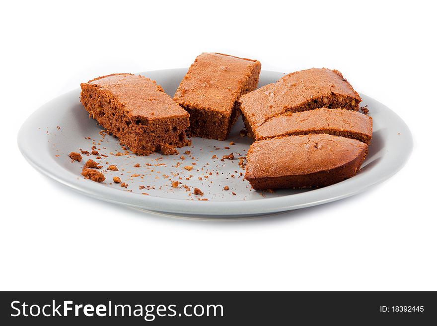 Brownies and crumbs on gray plate isolated on white background. Brownies and crumbs on gray plate isolated on white background