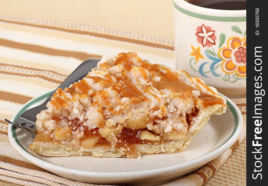 Apple pie topped with caramel and cup of coffee