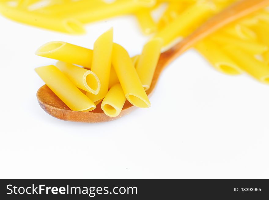 Penne and spoon isolated on white background