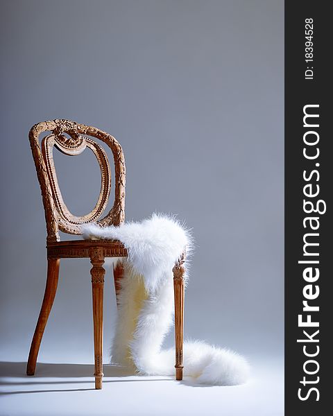 Old-fashioned wooden chair with white fur on it