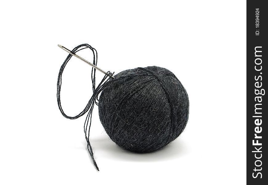 Black thread ball and needle on a white background