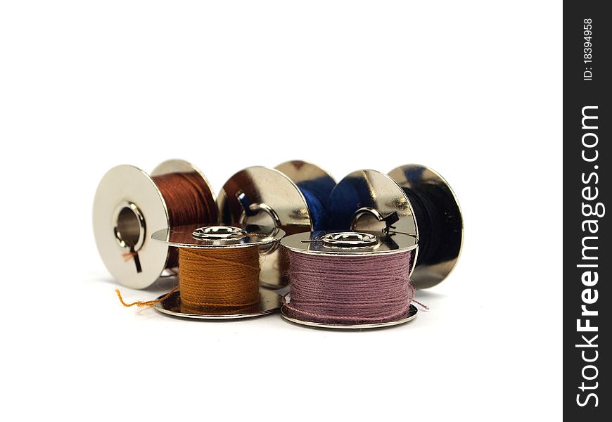 Colorful threads spools on white background