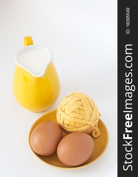 Pitcher of milk and eggs on a white background