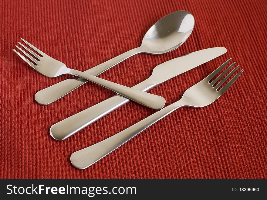 Set of flatware on red background top view