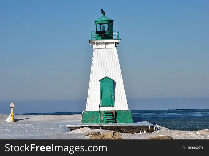Lighthouse on an ice covered pier,lake ontario. Lighthouse on an ice covered pier,lake ontario