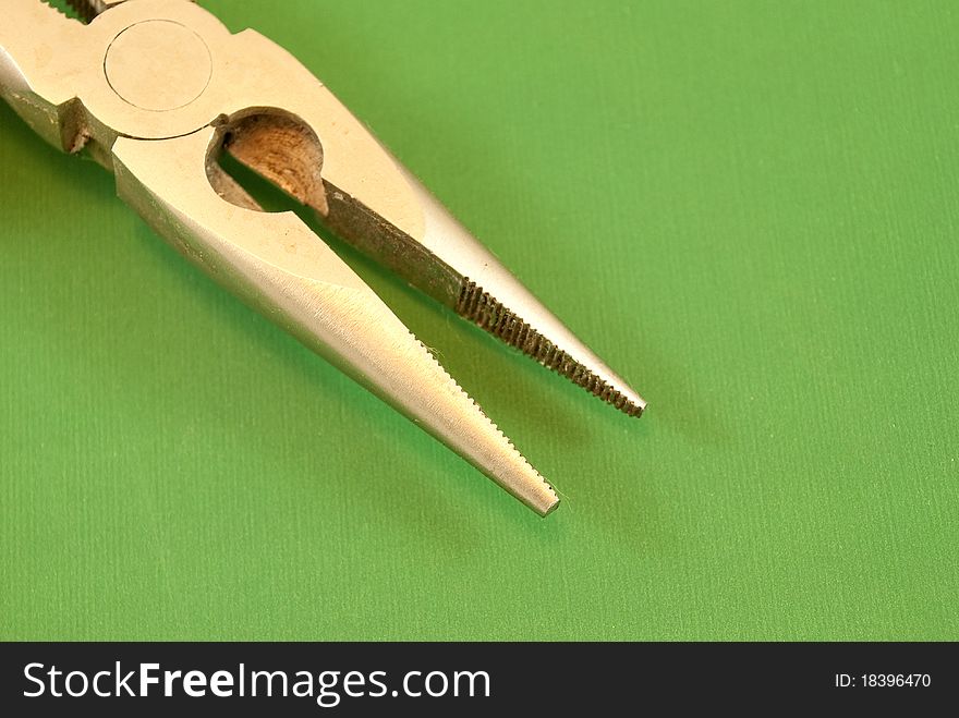 Pliers on a green background macro photography