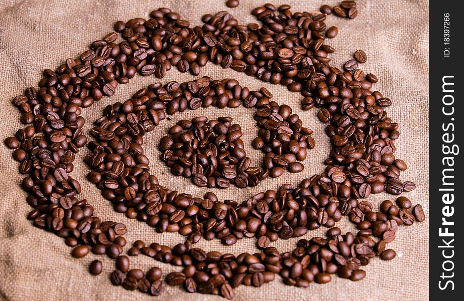 Grains of black coffee on a fabric.