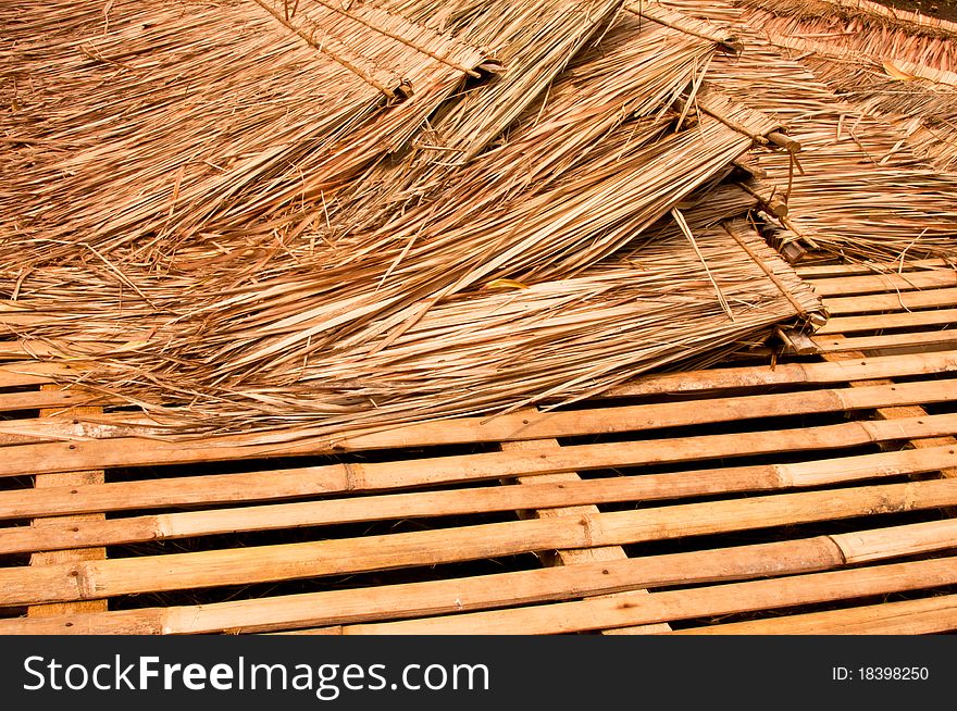 Pile of straw roof building material on a bamboo platform. Pile of straw roof building material on a bamboo platform