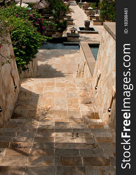 A directional natural granite stairway with outdoor fountain and lighting at a resort