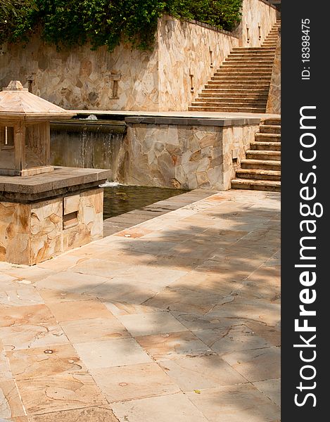 A directional natural granite stairway with outdoor fountain and lighting at a resort