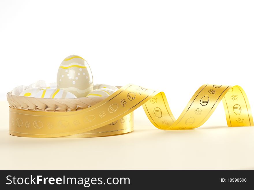 Easter egg in basket decorated with gold ribbon