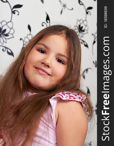 A happy little girl sitting on the sofa, smiling. A happy little girl sitting on the sofa, smiling