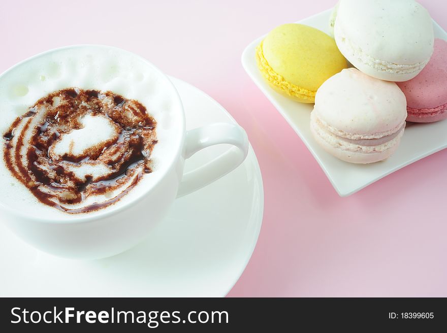 Cappuccino with macaroons on a pink background