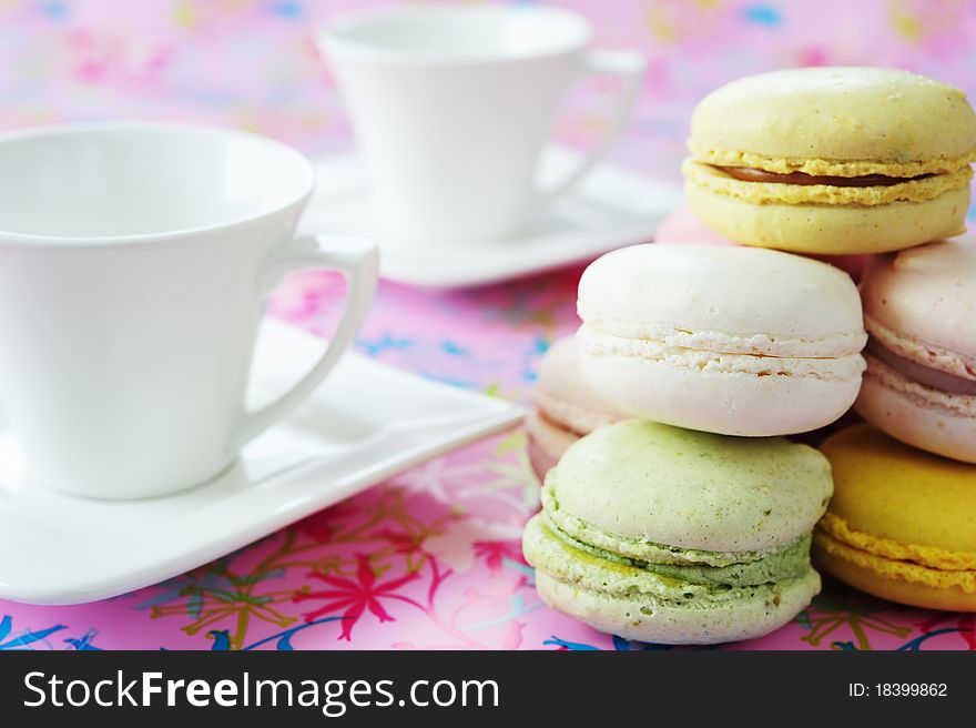 Macaroons and two white cups of tea on a pink background. Macaroons and two white cups of tea on a pink background